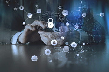 Poster - cyber security internet and networking concept.Businessman hand working with VR screen padlock icon on mobile phone and laptop computer background