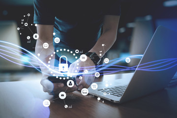 Poster - cyber security internet and networking concept.Businessman hand working with VR screen padlock icon on mobile phone and laptop computer background
