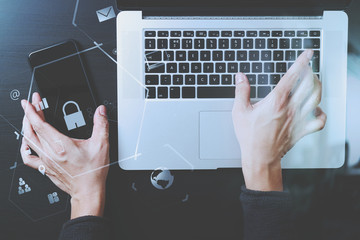 Poster - cyber security internet and networking concept.Businessman hand working with VR screen padlock icon mobile phone on laptop computer background