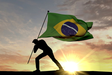 Wall Mural - Brazil flag being pushed into the ground by a male silhouette. 3D Rendering