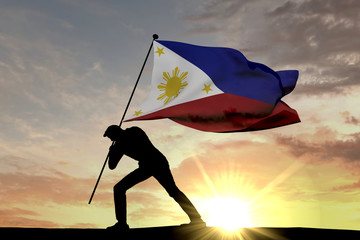 Wall Mural - Philippines flag being pushed into the ground by a male silhouette. 3D Rendering
