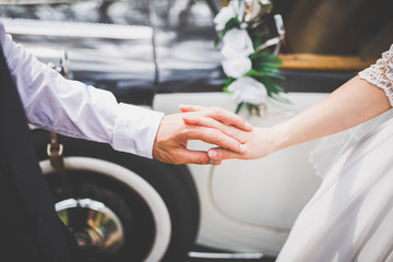 The man took the hand of a woman near the retro car