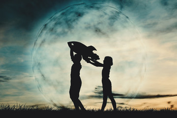 Silhouette boy and girl holding a rocket paper on the sky with moon background  color of vintage tone