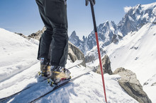 Low Section Of Hiker With Skis Standing On Snowcapped Mountain
