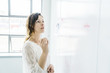 © Cavan Images - Side view of businesswoman writing on whiteboard in office