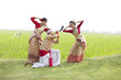 Bihu man playing on a pepa while Bihu women dance to his tune 