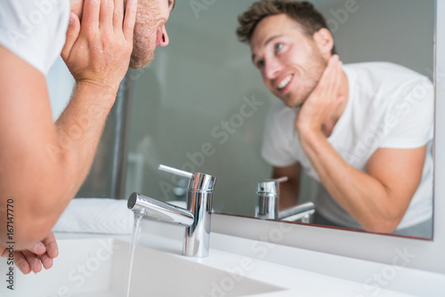 Man Washing Face In Sink In Bathroom Rinsing After Shaving