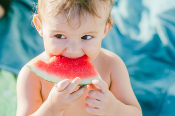 Little boy on holiday eating watermelon