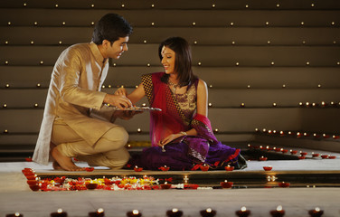 Couple arranging diyas