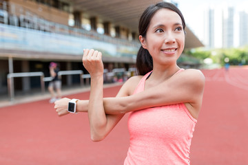 Wall Mural - Sport woman stretching arm in sport stadium