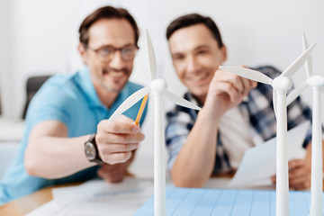 Sticker - Smiling man pointing at a wind turbine model with pencil