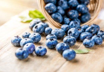 Poster - Freshly blueberries on wooden rustic wooden table. Juicy and fresh blueberries with green leaves. Bilberry on wooden background. Blueberry antioxidant. Concept for healthy eating and nutrition.