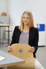 Canvas Print - junge frau sitzt lässig im büro am schreibtisch