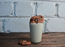 Homemade Cookies With Chocolate Put In A Glass With Natural Yoghurt On A White Brick Wall Background.