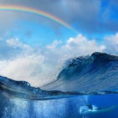 Fototapete - Oceanview splitted underwater side with mantaray surrounded by air bubbles and shorebreak big waves with colored rainbow
