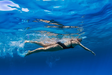 Wall Mural - Swimmer in deep blue water of sea