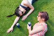 © LIGHTFIELD STUDIOS - high angle view of multiethnic girls with soda cans smiling each other while lying on lawn
