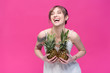 © LIGHTFIELD STUDIOS - beautiful young woman holding pineapples and laughing isolated on pink