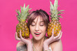 © LIGHTFIELD STUDIOS - beautiful smiling young woman with closed eyes holding pineapples isolated on pink