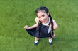 © LIGHTFIELD STUDIOS - high angle view of beautiful smiling asian girl posing while standing on green grass