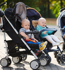 funny children sitting in strollers in park