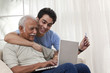 © IndiaPix - Grandson teaching grandfather how to operate laptop