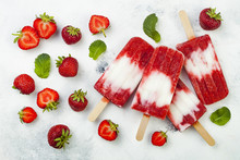 Homemade vegan strawberry coconut milk popsicles - ice pops - paletas on rustic white background