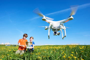 Wall Mural - children operating of flying drone at sunset