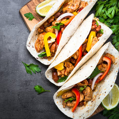 Canvas Print - Mexican taco with meat beans and vegetables. Top view on black stone background. 