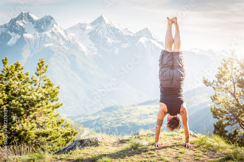 Fotografie, Obraz Ragazzo in verticale con panorama di montagna, a testa in giu