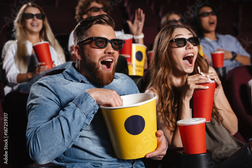 Fotografía Laughing friends sitting in cinema watch film