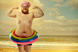 © Studio Romantic - Funny man in a swimsuit with an inflatable circle on the beach