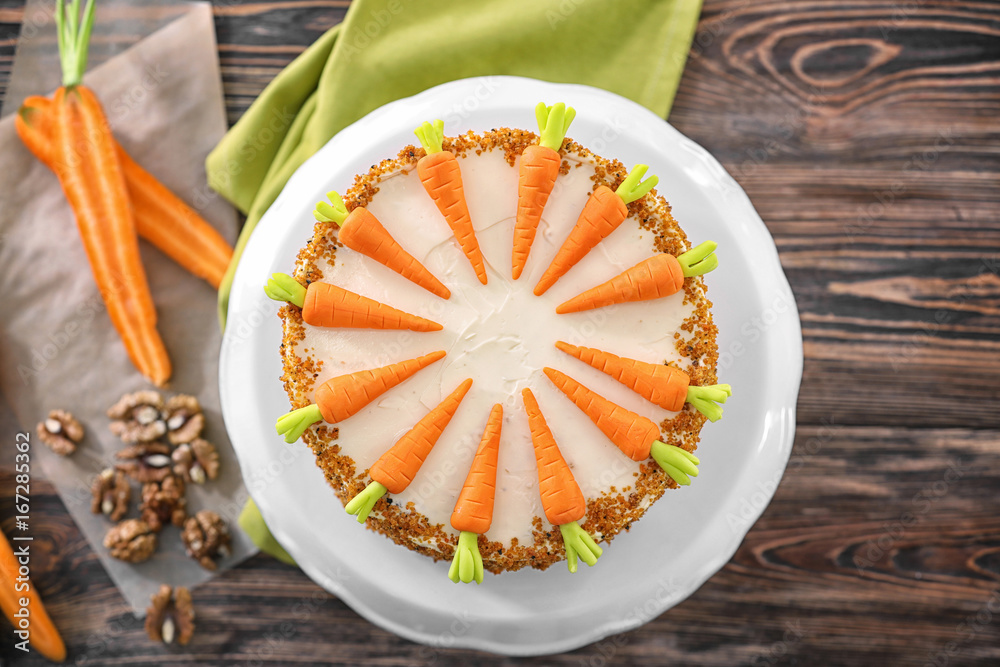 Stand with delicious carrot cake on wooden background