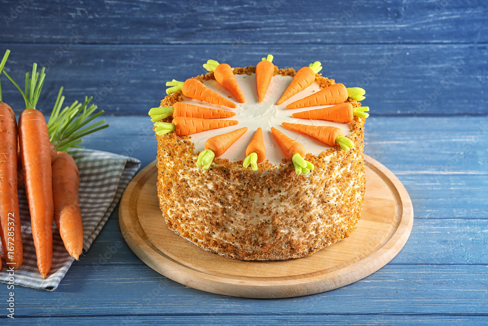 Board with delicious carrot cake on wooden table