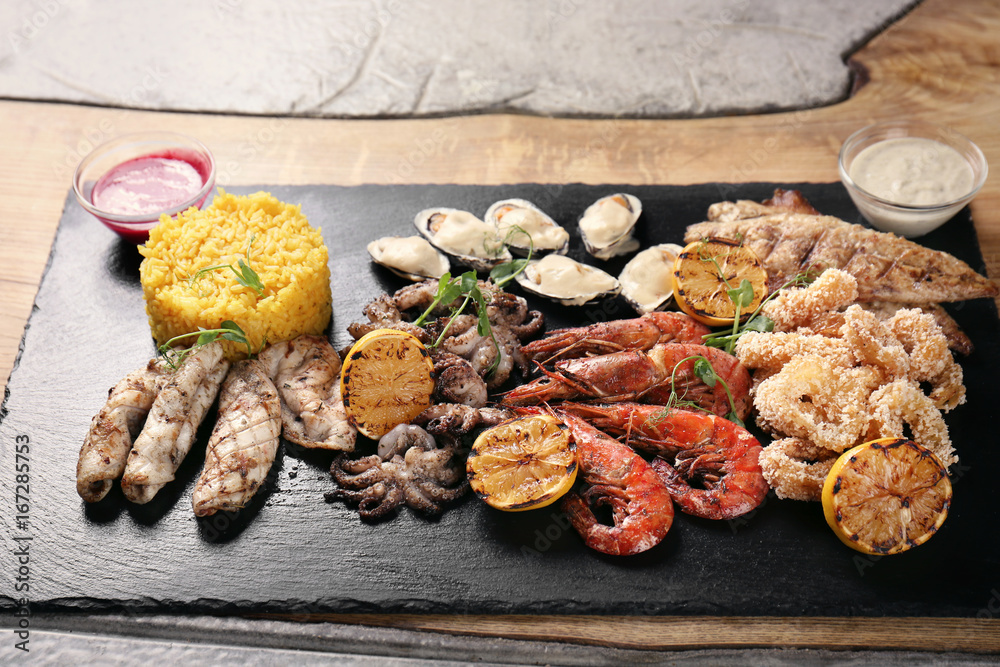 Variety of seafood with rice on slate plate