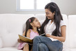 © IndiaPix - Mother and daughter sitting together with a story book
