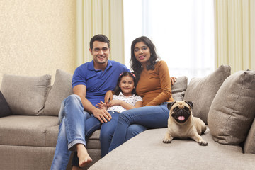 Portrait of smiling family with daughter and pug 