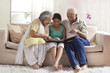 © IndiaPix - Granddaughter looking at a photo album with her grandparents