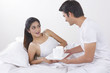 © IndiaPix - Young man holding tray of coffee cups by surprised woman in bed