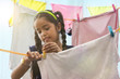 Young girl drying a cloths on a clothesline