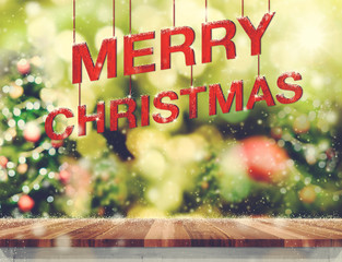 Aufkleber - Merry Christmas red wood word hanging over wood table top with blurred Christmas tree bokeh light and snow background,Holiday greeting card.