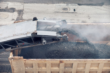 Road works. Asphalt removing machine loading powdered asphalt on the truck