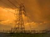 Fototapeta  - Silhouette of high voltage power plant and transformation station at sunset : selective focus at .barbed wire