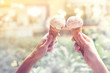 © oatawa - Two young woman hands holding ice cream cones on summer