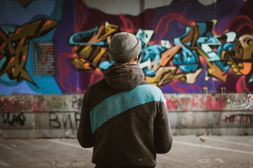 Graffiti artist standing near the wall