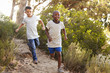 © Monkey Business - Two happy young boys running down a forest path