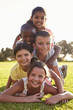 © Monkey Business - Smiling boys and girls lying in a pile on grass in Summer