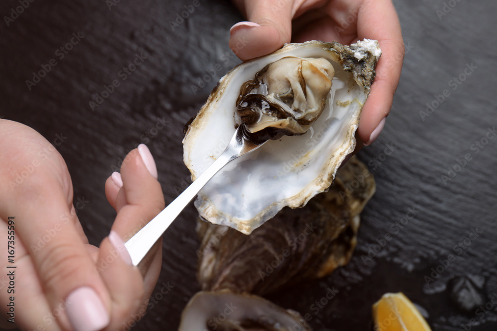 Woman eating delicious oyster, closeup