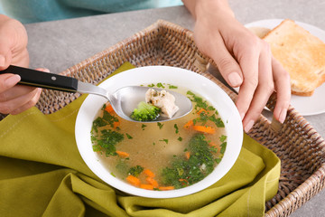 Poster - Woman eating homemade chicken soup on wicker tray