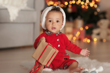 Wall Mural - Cute little baby with Santa hat and gift box in decorated for Christmas room